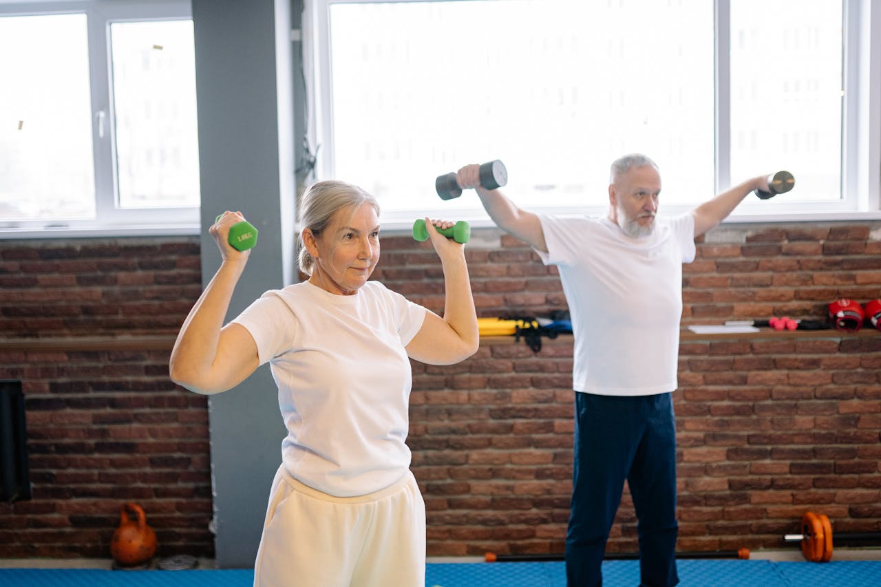 hero-img-02 Elderly man and woman workout with dumbbells promoting healthy lifestyle and fitness.